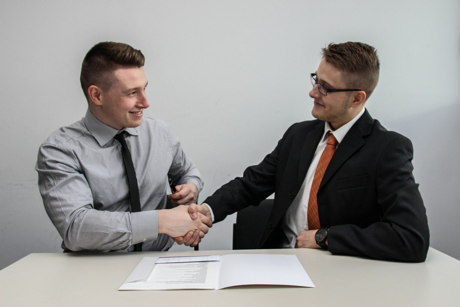 A reassuring handshake between an attorney and a client in a bright office